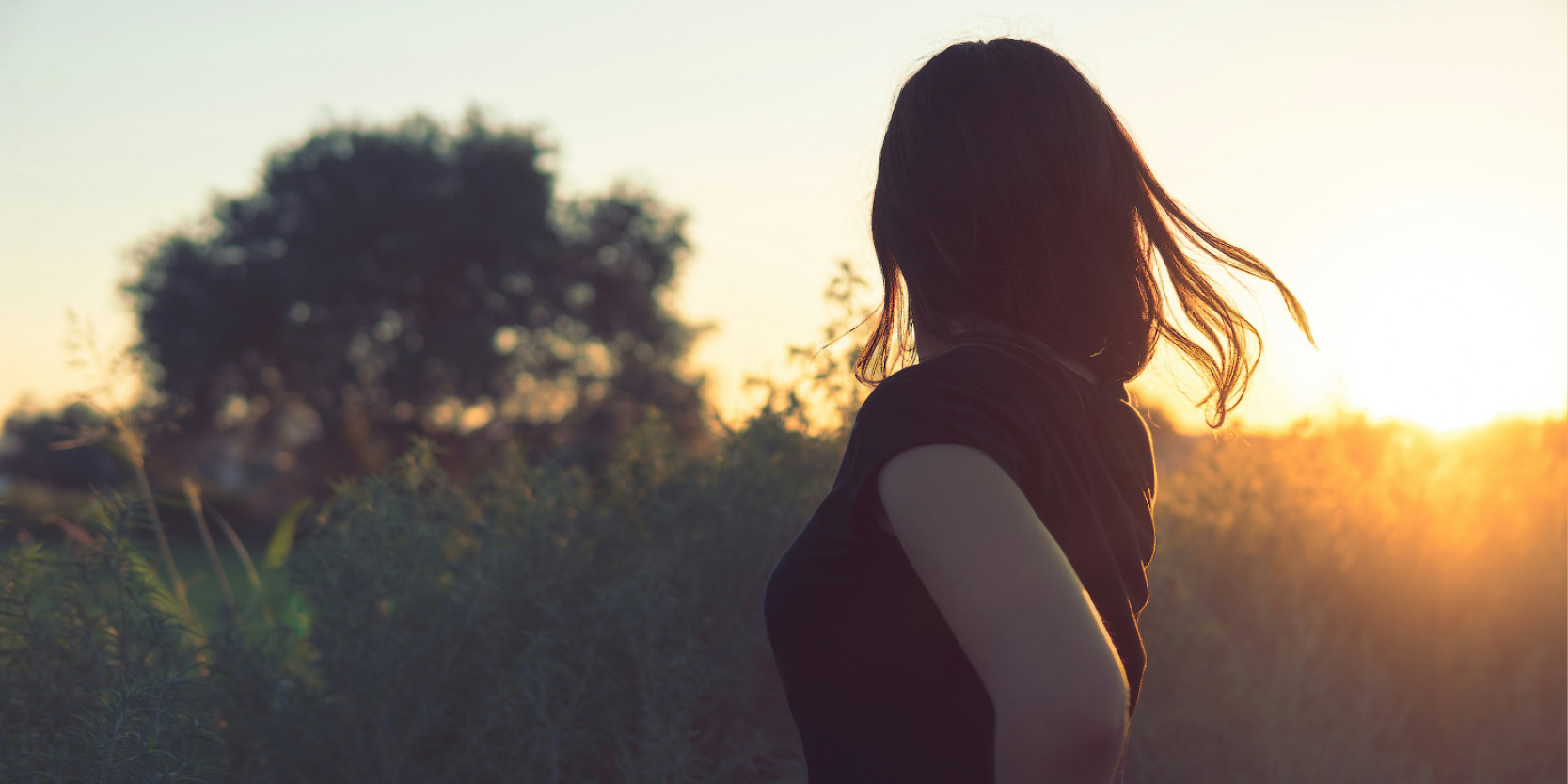 Donna di spalle al tramonto