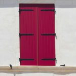 Imposte di legno rosse di una finestra chiuse