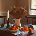 Un tavolo son sopra un vaso di fori, piccole zucche e candele