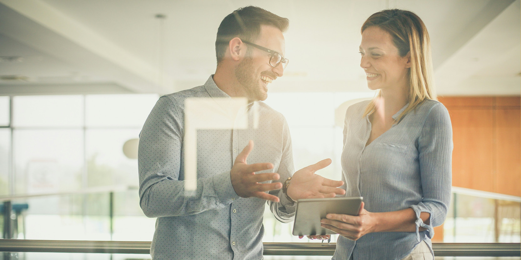 uomo e donna che in ambiente lavorativo si confrontano sorridendo