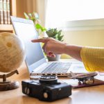 Mano che indica lo schermo di un computer su una scrivania 