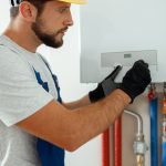 Operaio tecnico in tenuta da lavoro che sistema una caldaia